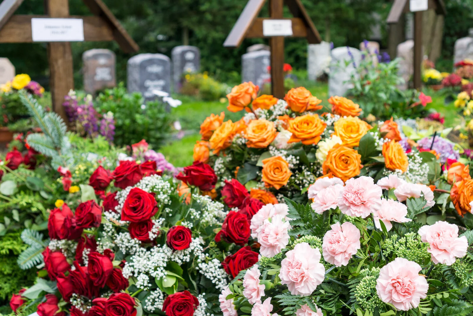 Blumenschmuck vor Gräbern auf einem Friedhof